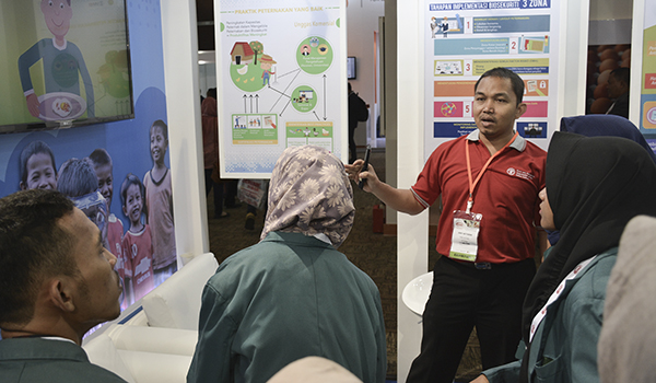Man presenting biosecurity to visitors of exhibition in Indonesia.