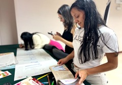 Young women working on an educational project with books and posters.