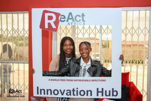 Two participants holding up a photo frame with the ReAct Africa logo at the launch event in Lusaka, Zambia, smiling and enjoying the moment.