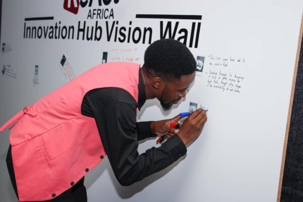 Participant writing ideas on the Innovation Hub Vision Wall.